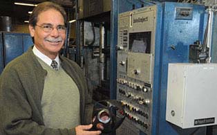 Manufacturing manager standing in front of piece of manufacturing equipment